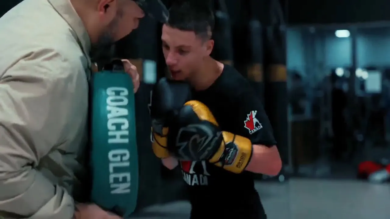 Coach holding pads for a boxer during a private session